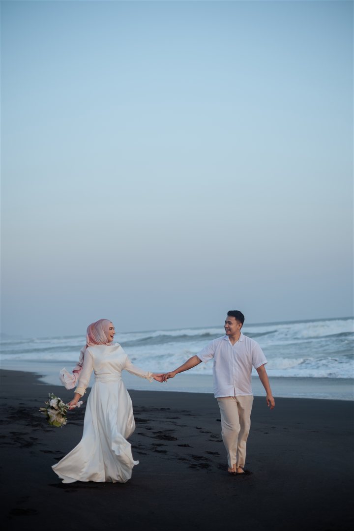 Nadira dan Widdy bergandengan tangan di pantai